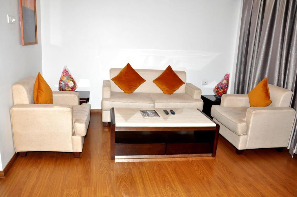 uma sala de estar com dois sofás e uma mesa de centro em Triguna Clarks Inn Kurnool em Kurnool