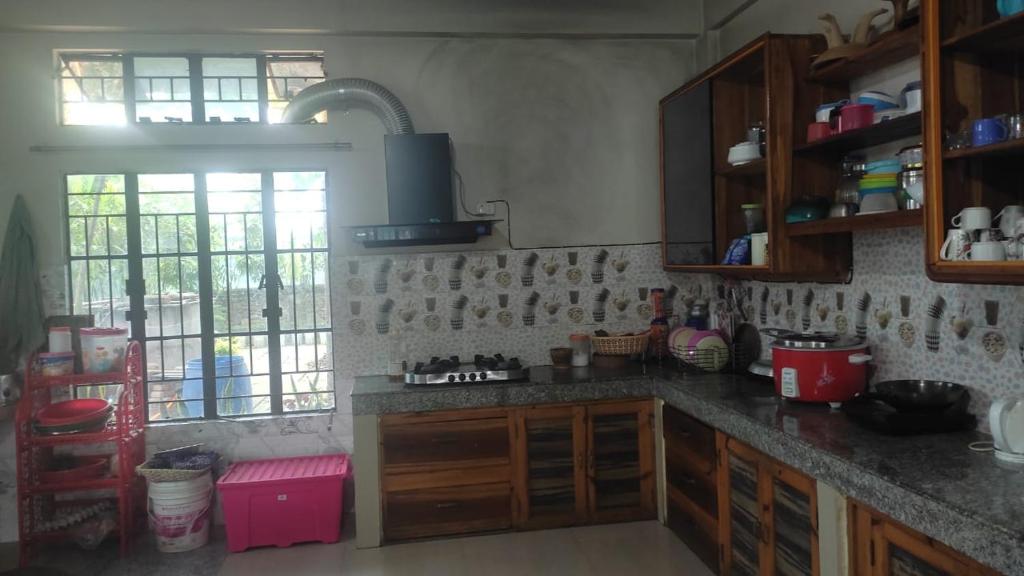 - une cuisine avec des placards en bois et un comptoir dans l'établissement Vosu Homestay, à Dimāpur