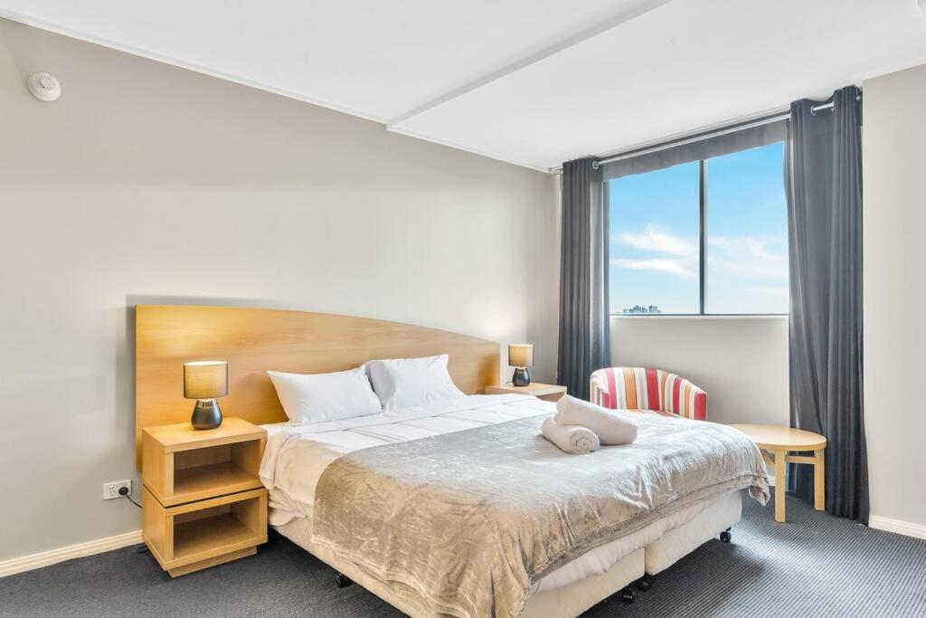 a bedroom with a large bed and a window at Comfortable King Bed Studio in Rose Hill with Parking in Sydney