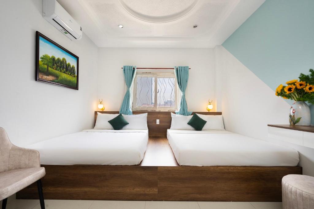 2 camas en una habitación con ventana en Vivianne Boutique Hotel, en Ho Chi Minh