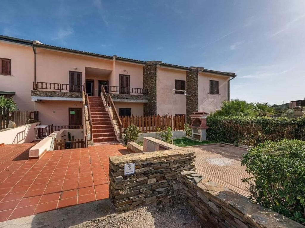 una casa con una pared de piedra y una escalera en Property in Stintino SS, en Villa Sirena