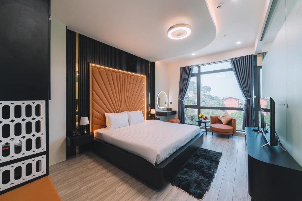 um quarto com uma cama e uma grande janela em Greenview Hotel DaLat em Da Lat