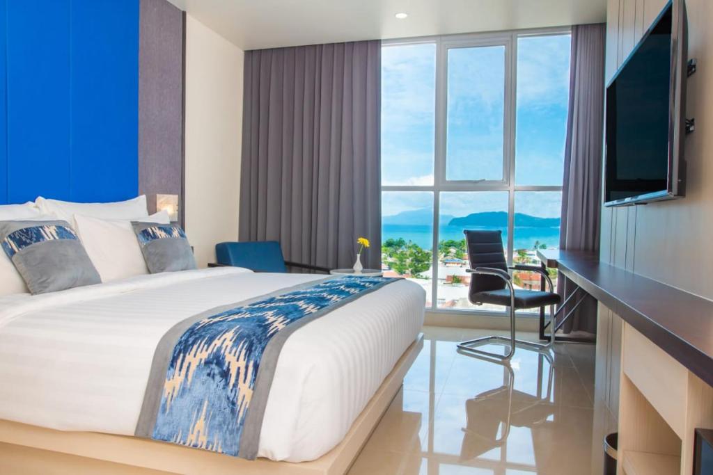 a bedroom with a large bed with a view of the ocean at Horison Ultima Entrop Papua in Jayapura