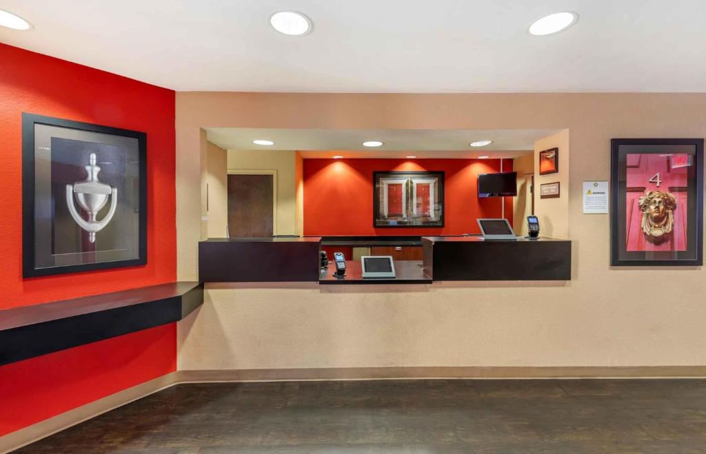 vestíbulo del hotel con paredes rojas y recepción en Relax Suites Extended Stay - La Mirada en La Mirada