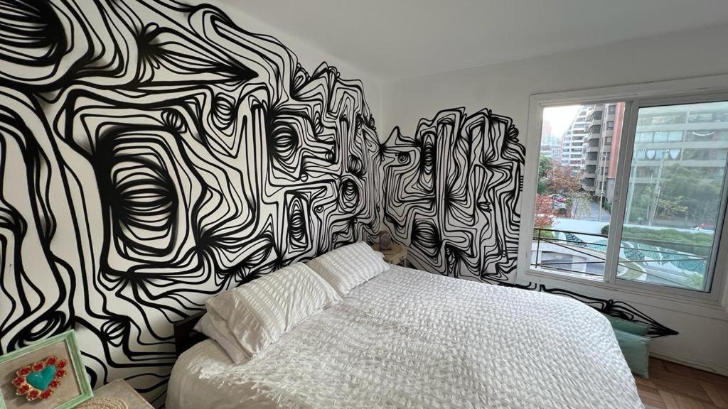 a bedroom with a black and white patterned wall at Art Apartment in Santiago