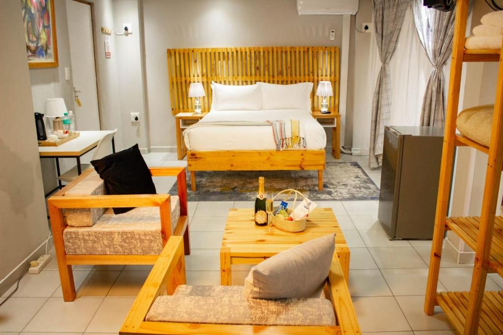 um quarto com uma cama, uma mesa e cadeiras em Thabeng Hotel & Restaurant em Maseru