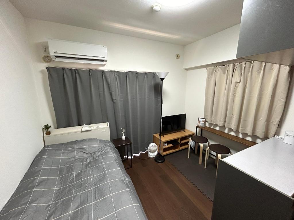 ein Schlafzimmer mit einem Bett und ein Fenster mit einer Heizung in der Unterkunft Guest House Raffine HAKATA in Fukuoka