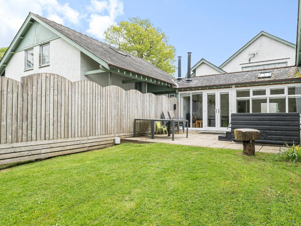 une maison avec une clôture en bois et une cour dans l'établissement Hazel - Woodland Cottages, à Bowness-on-Windermere