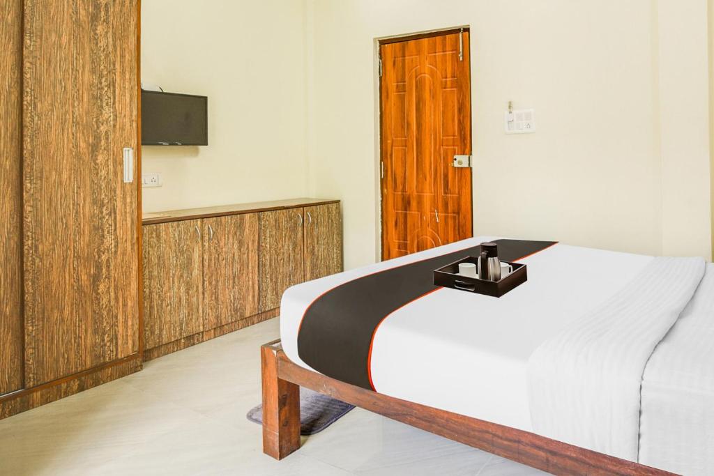 a bedroom with a bed and a tv on the wall at Hotel Joaquim Near Baga Beach in Baga