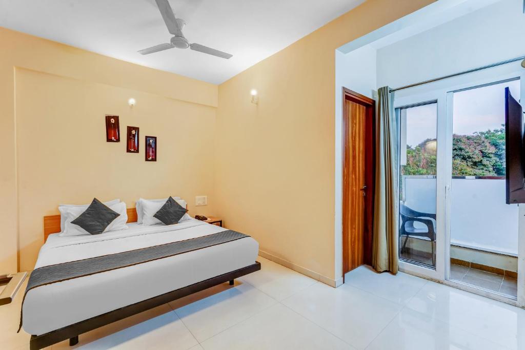 a bedroom with a bed and a large window at UPAR Hotels near Bagmane Tech Park in Bangalore