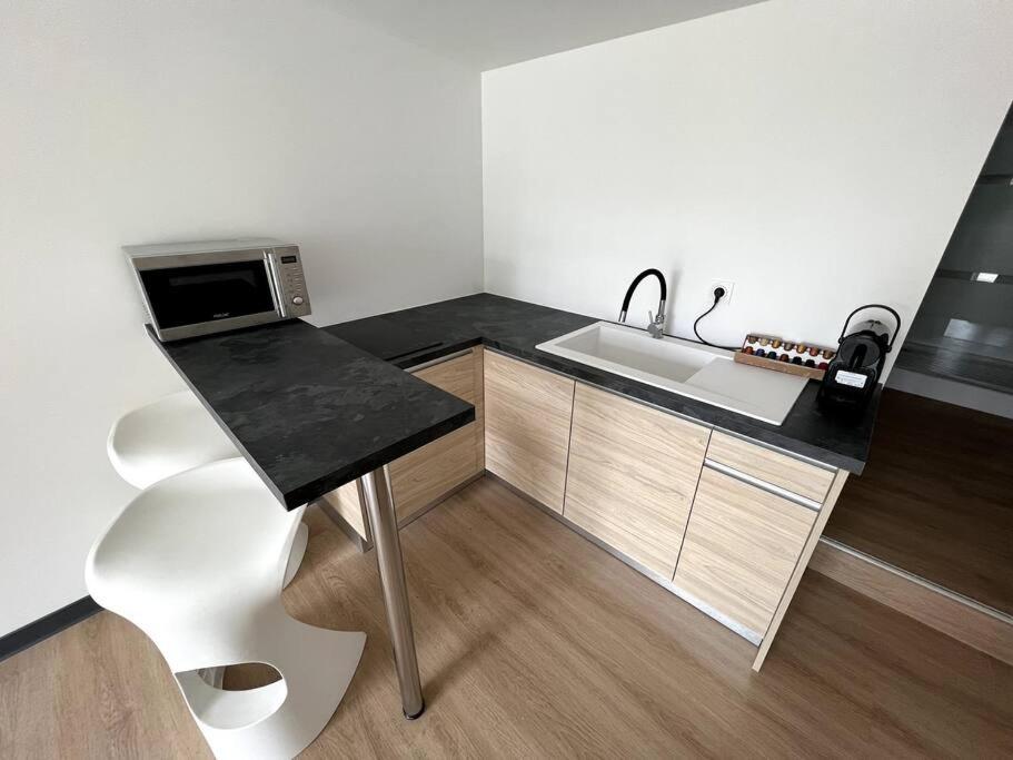 a small kitchen with a sink and a counter at Caliente AnseVata Studio in Noumea