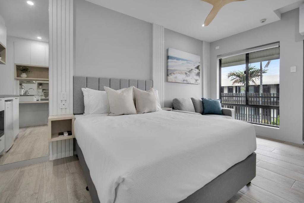 duża biała sypialnia z dużym łóżkiem i kuchnią w obiekcie Belmoral Corporate Suites w mieście Townsville