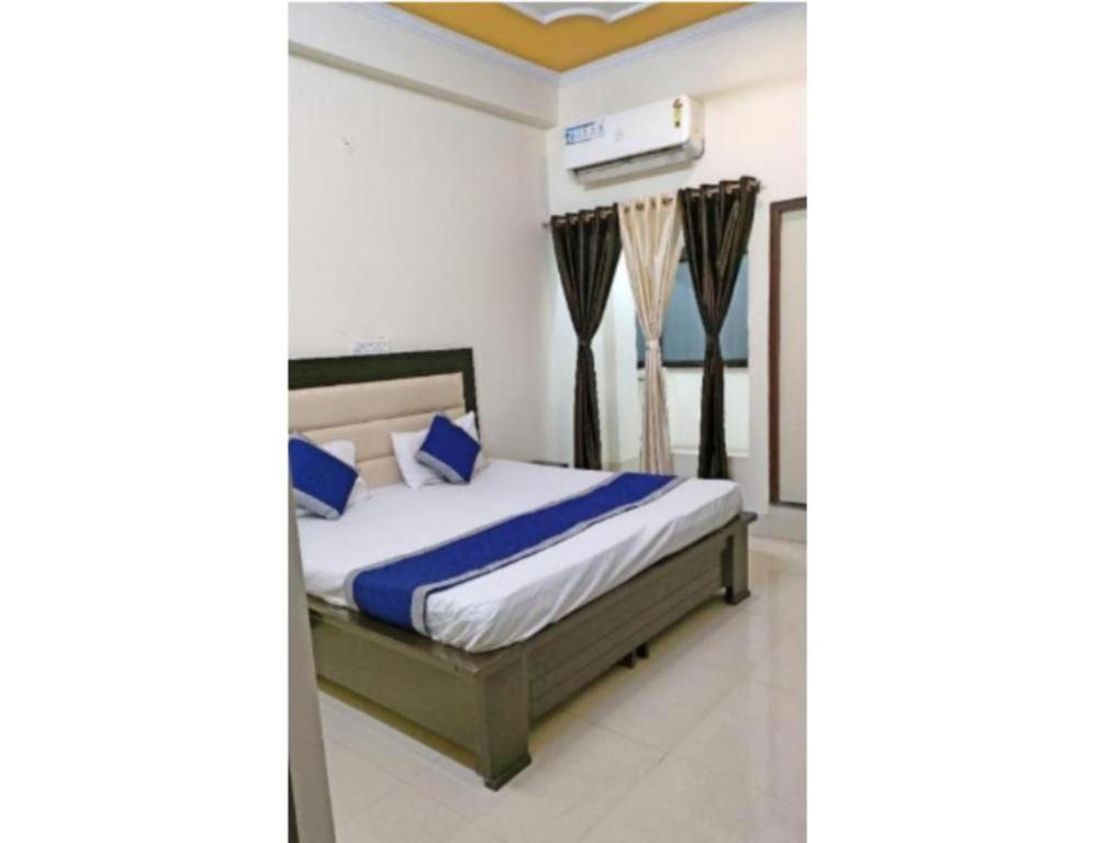 Goroomgo Radhika Kunj Palace Chhatarpur في Chhatarpur: غرفة نوم مع سرير ووسائد زرقاء