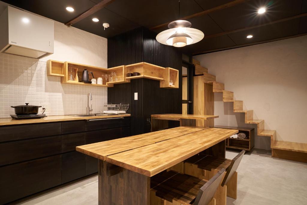 a kitchen with a wooden table and a staircase at OldbutNew 蔵 in Hara