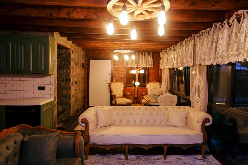 a living room with a white couch in a room at KOZLUCA Bungalov in Trabzon