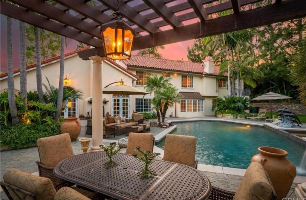 a patio with a table and chairs and a swimming pool at @ Marbella Lane - Hidden Gem in Orange County in Orange