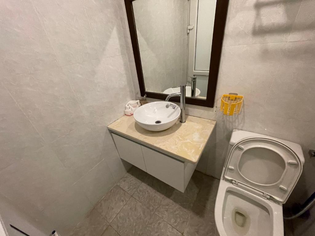 Un baño con lavabo, inodoro y espejo. en Đặt phòng chính chủ Hạ Long Lh, en Ha Long