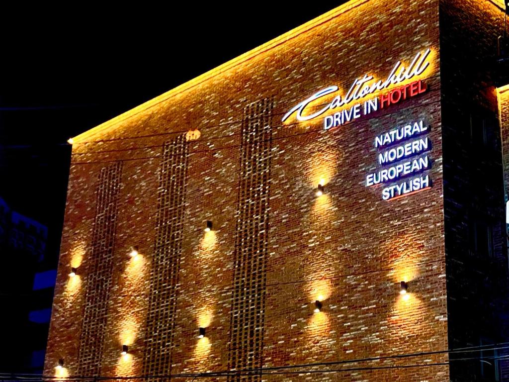 a brick building with lights on the side of it at Calton Hill Hotel in Jeonju