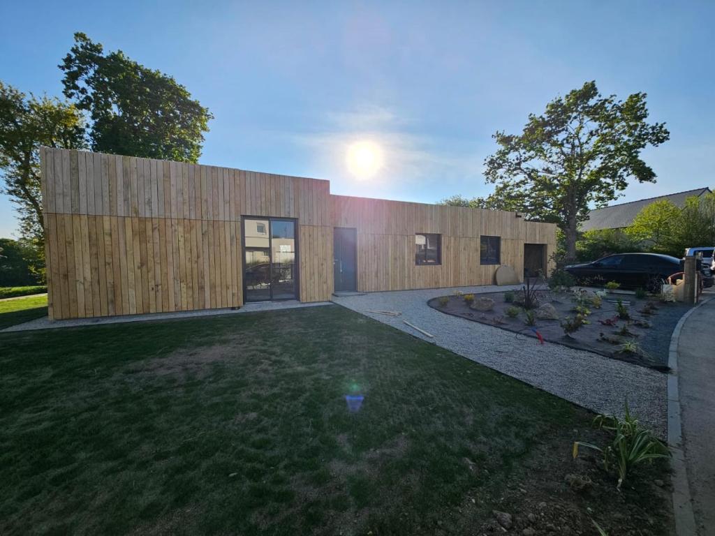 a house with a wooden facade with a yard at Villa Gwin Zegal in Plouha