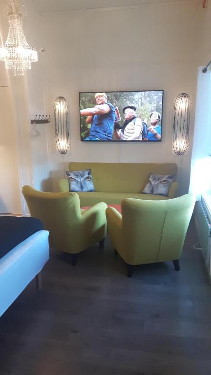 sala de estar con sofá y TV de pantalla plana en Båtsfjord Smarthotell en Båtsfjord