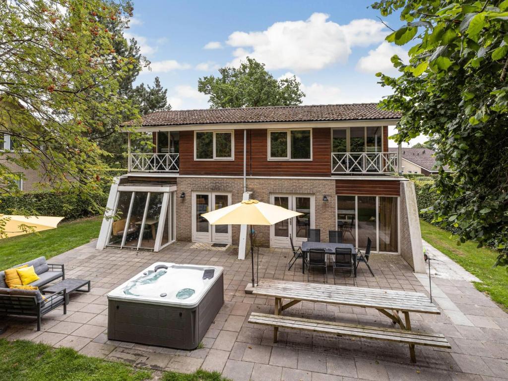 a house with a patio with a hot tub at Spacious Retreat, Vlagtwedde in Vlagtwedde