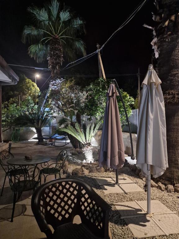 two umbrellas sitting on a patio at night at Villa OLD FISHERMAN'S in Taranto