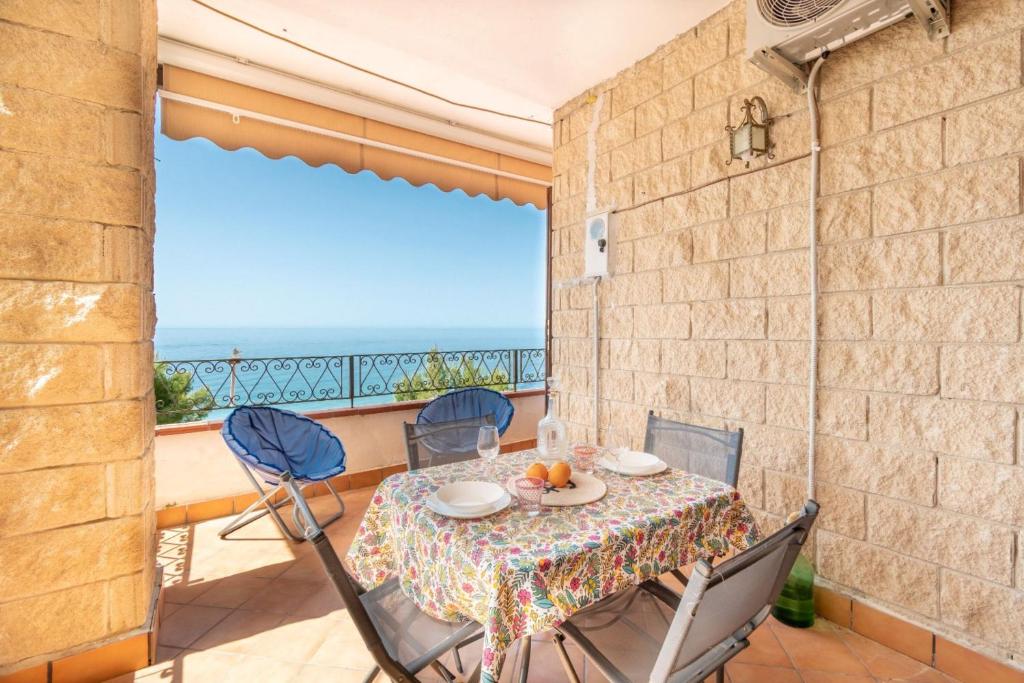una mesa y sillas en un balcón con vistas al océano en Le terrazze di Acciaroli - Happy Rentals, en Acciaroli