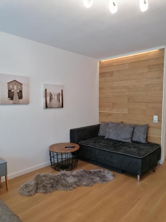 a living room with a black couch and a table at Ferienwohnung in Veitshöchheim in Veitshöchheim