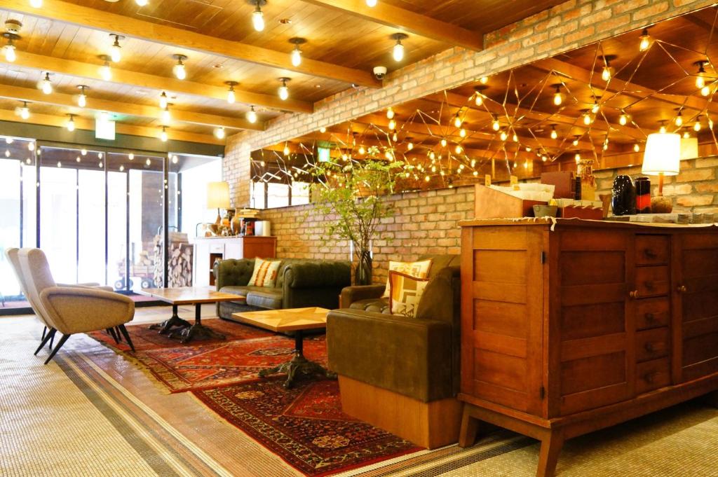 札幌的住宿－UNWIND Hotel & Bar Sapporo，客厅配有沙发和桌椅