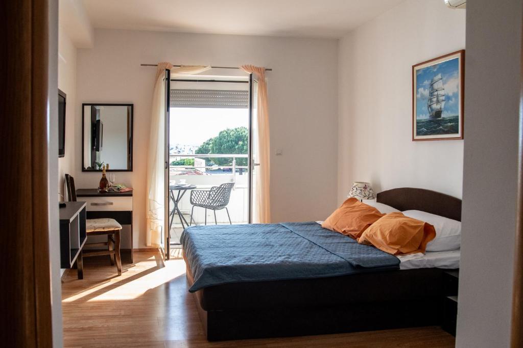 1 dormitorio con 1 cama y balcón en Guest House Maritimo, en Sukošan