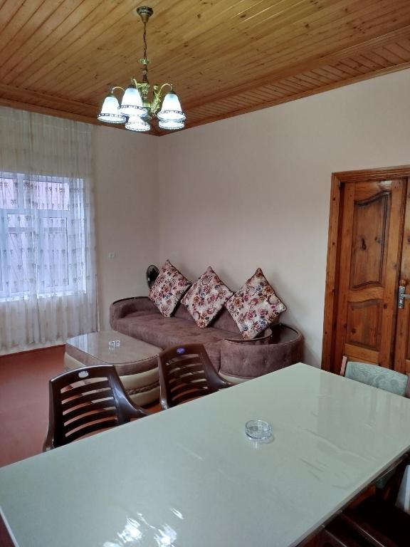ein Wohnzimmer mit einem Tisch und einem Sofa in der Unterkunft Hostel ucuz in Länkäran