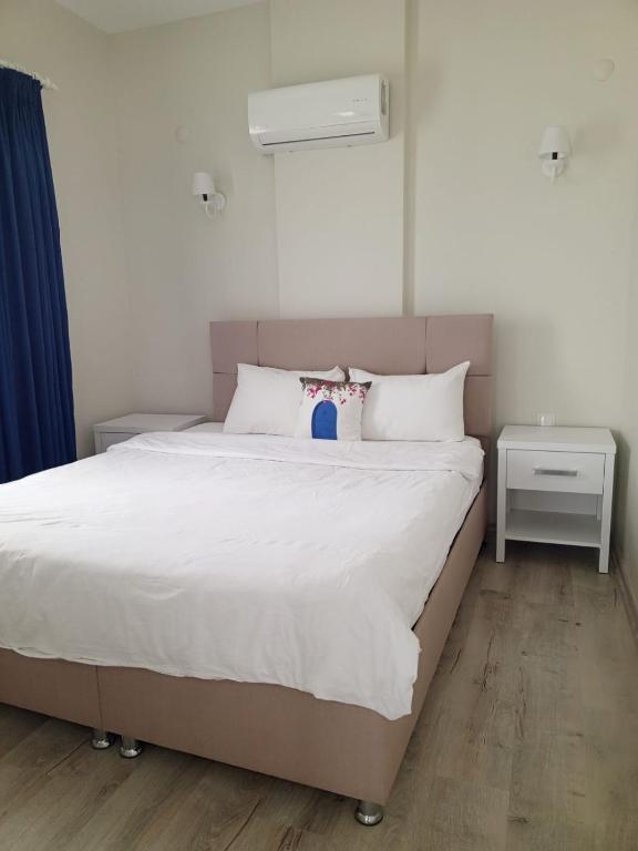 a bedroom with a large bed with white sheets at Port Hotel, Tasucu in Silifke
