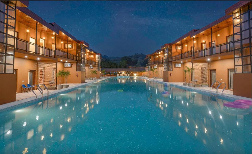 a large swimming pool in a hotel at night at Vanya - Urban Villa and Resorts in Belparāo