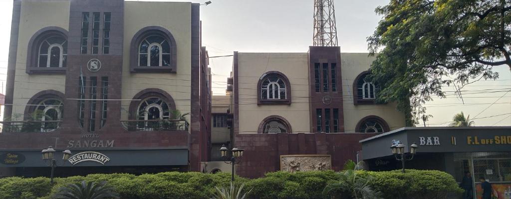 un gran edificio con un reloj en la parte delantera en Hotel Sangam, en Baharampur