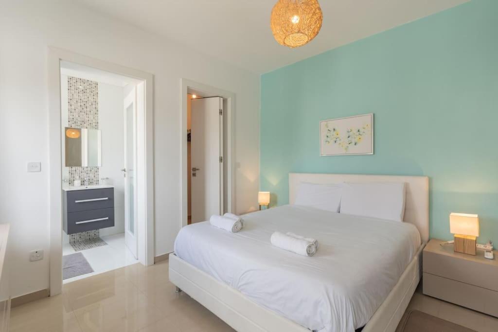 - une chambre avec un lit blanc et une salle de bains dans l'établissement St Julians apartment-Hosted by Sweetstay, à San Ġiljan