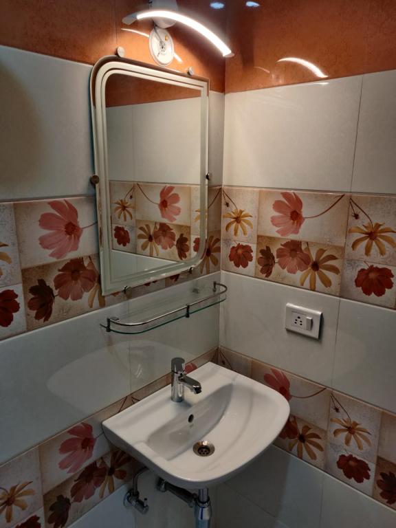 a bathroom with a sink and a mirror at Hotel Benaras Gharana Inn in Varanasi
