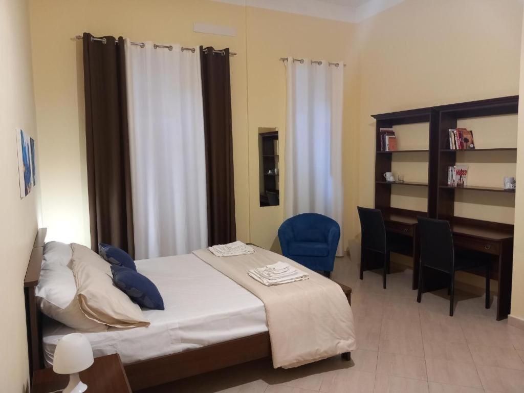 Un dormitorio con una cama con un escritorio y sillas. en NARBONE 42, en Palermo
