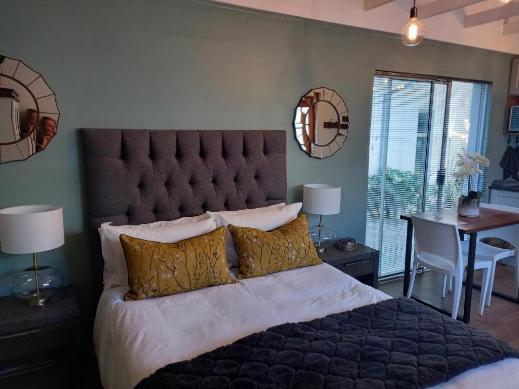 a bedroom with a large bed with gold pillows at Fevertree cottage in Bloemfontein