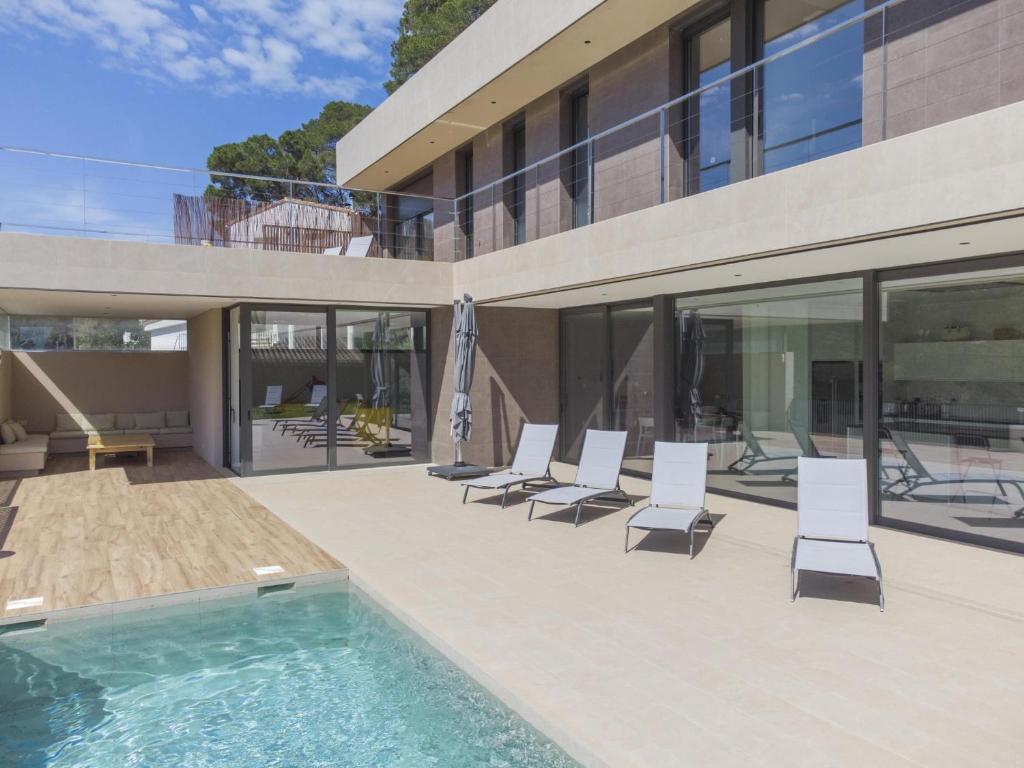 a house with a swimming pool and lounge chairs at Villa Clarisse in Tamariu