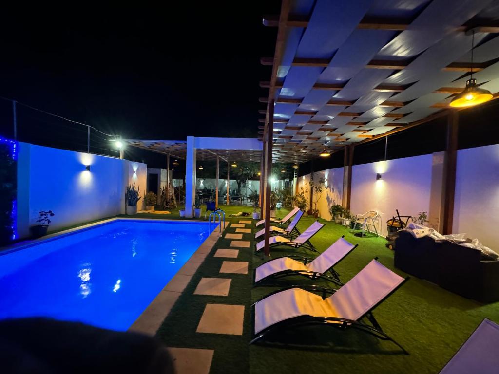uma piscina com espreguiçadeiras ao lado à noite em Pereira lounge bar em Praia