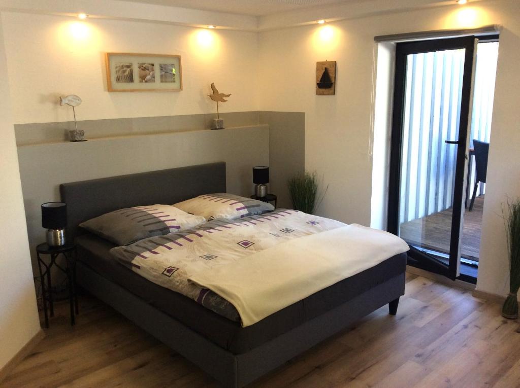 a bedroom with a bed and a large window at Ferienwohnung - Michaelas HUUS - zwischen den Meeren, Trappenkamp in Trappenkamp