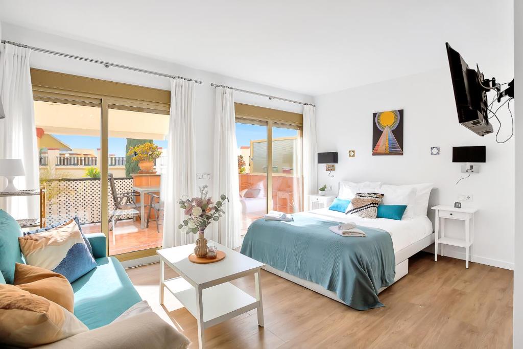 sypialnia z łóżkiem i kanapą oraz balkonem w obiekcie Modern beach apartment Romana Playa 723 in Marbella, Elviria w Marbelli