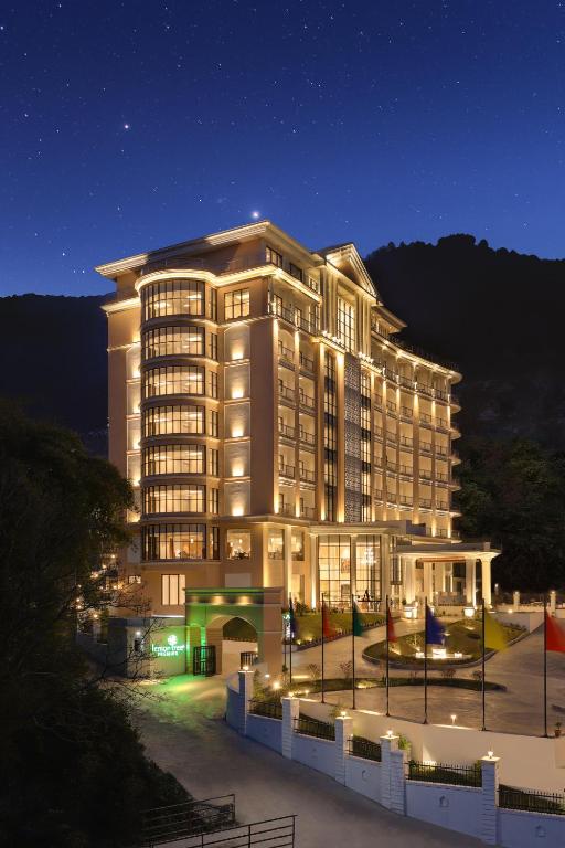 Un gran edificio con luces en el frente por la noche. en Lemon Tree Premier Budhanilkantha Kathmandu, Nepal, en Katmandú