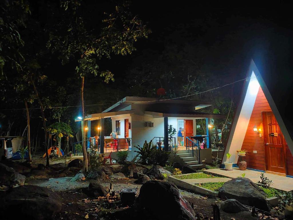 een klein huis met een verlichte gevel in de nacht bij Camp Asgard by Camiguin Viajeros House Rentals in Catarman