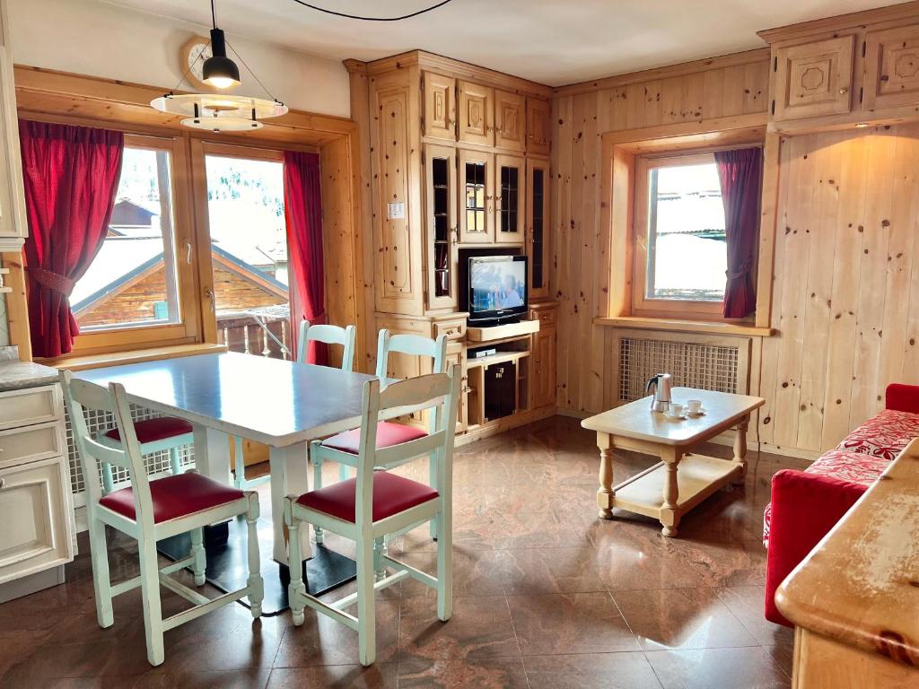 uma cozinha com mesa e cadeiras num quarto em Bike&Ski Saroch Apartments em Livigno