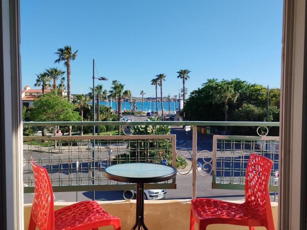 d'un balcon avec une table et deux chaises et une vue. dans l'établissement Plage des Lônes et Sanary Port, à Six-Fours-les-Plages