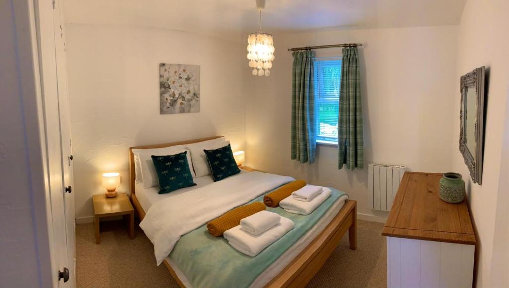 a small bedroom with a bed with two pillows at The Lodge@Tyddyn Ucha in Caernarfon