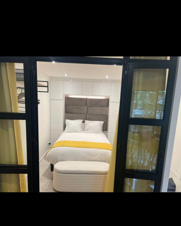 une petite chambre avec un lit et une fenêtre dans l'établissement Deux. Pièces face à la scène., à Neuilly-sur-Seine