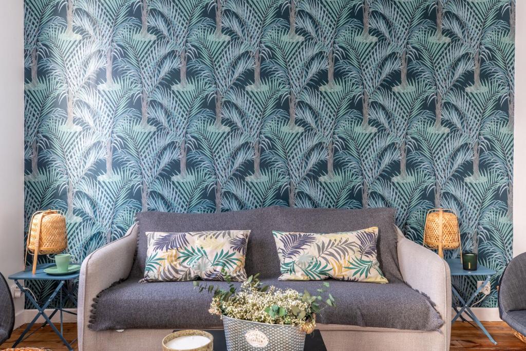 een bank in een woonkamer met een muur bij La maison de Vallières in Clermont-Ferrand