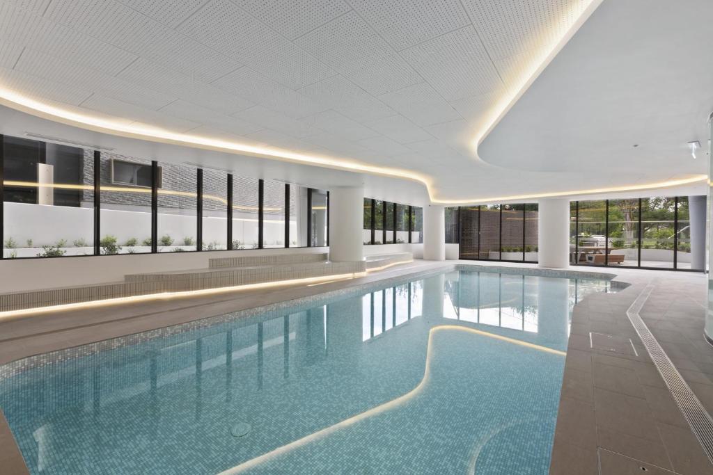 einem Pool in einem Gebäude mit einer großen Decke in der Unterkunft Light Filled Apartment by Albert Park & Lake in Melbourne